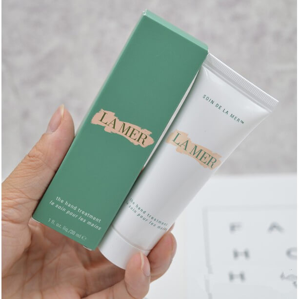 La Mer The Hand Treatment 30 ml.  ทรีทเมนต์บำรุงมือนุ่มลื่นดุจแพรไหม ช่วยปลอบประโลมผิวในทันทีที่สัมผัส พร้อมเสริมปราการปกป้องและกักเก็บความชุ่มชื้น ส่วนผสม Skin Lightening Complex™   ช่วยปรับสีผิวให้สม่ำเสมอ และลดเลือนจุดด่างดำแห่งวัย ผสานพลังกับน้ำสกัดเข้มข้น Miracle Broth™ หัวใจหลักสำคัญในการช่วยฟื้นบำรุงผิวของลาแมร์ ช่วยปกป้องและปลอบประโลมแม้ผิวที่แห้งที่สุด